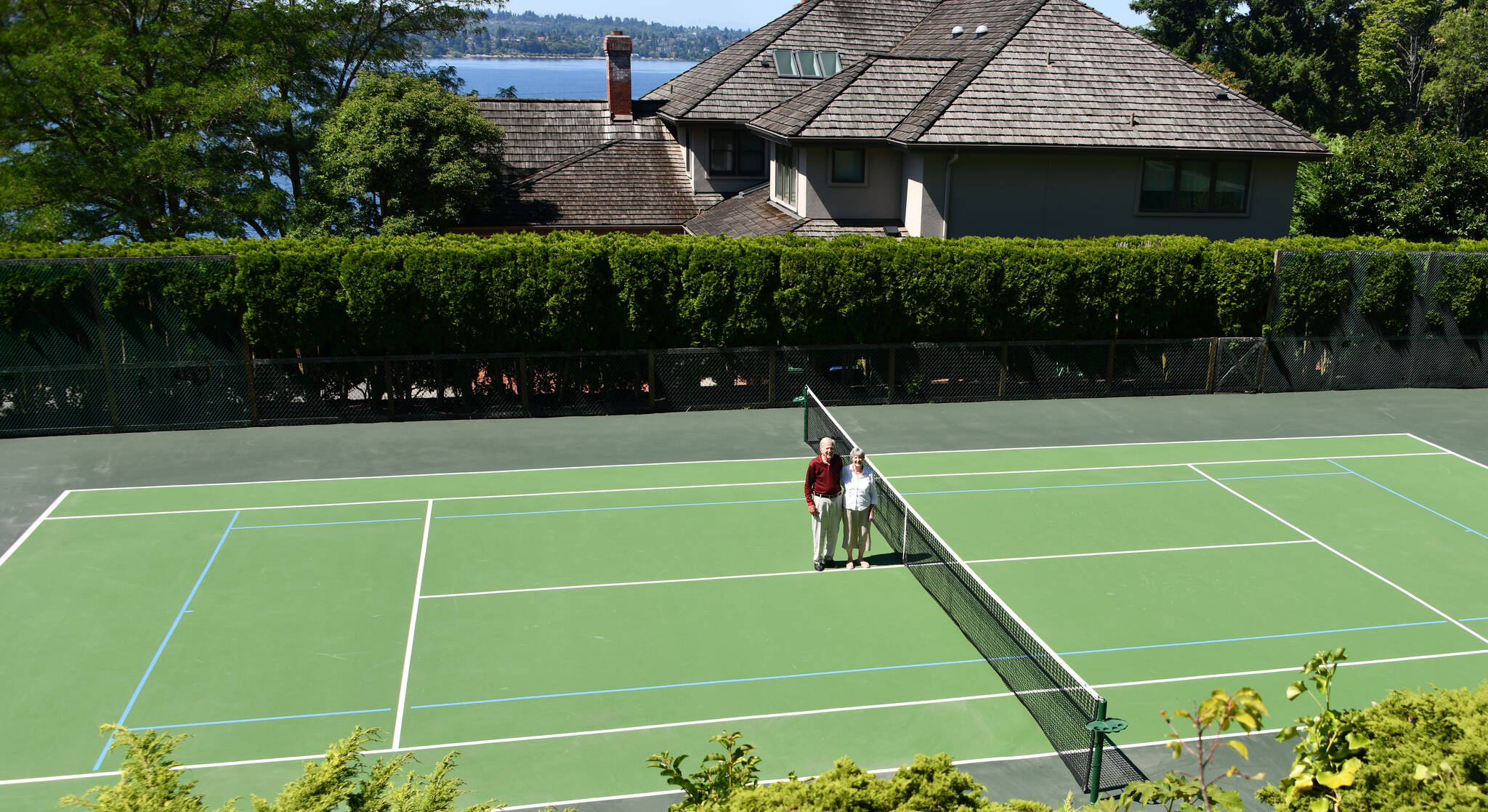 Charles Chick and Linda Hodge stand at center court at their tennis facility on Mercer Island. Andy Nystrom/ staff photo