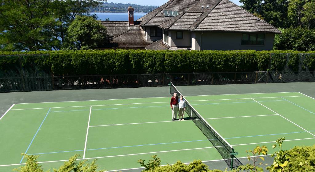 Charles Chick and Linda Hodge stand at center court at their tennis facility on Mercer Island. Andy Nystrom/ staff photo