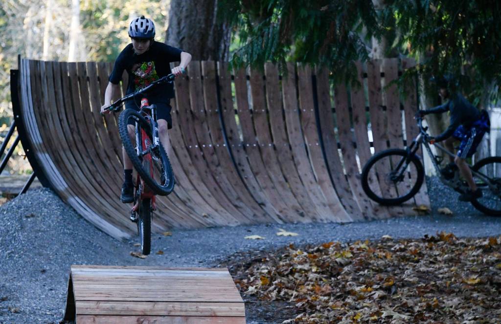 Miles Bailey from the Mercer Island Mountain Bike team gets air while another rider rolls through the new Bike Skills Area, which opened to the public on Nov. 15 at Deanes Childrens Park. Andy Nystrom/ staff photo