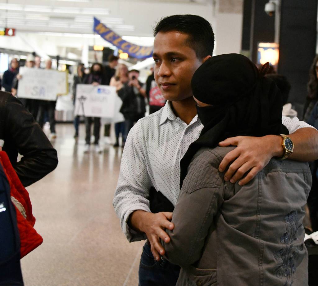 Mohamad Imran reunites with family members, some of whom he hasnt seen since he was 12, on Dec. 8 at Seattle-Tacoma International Airport. Mercer Island friends and supporters gather in the background. Andy Nystrom/ staff photo