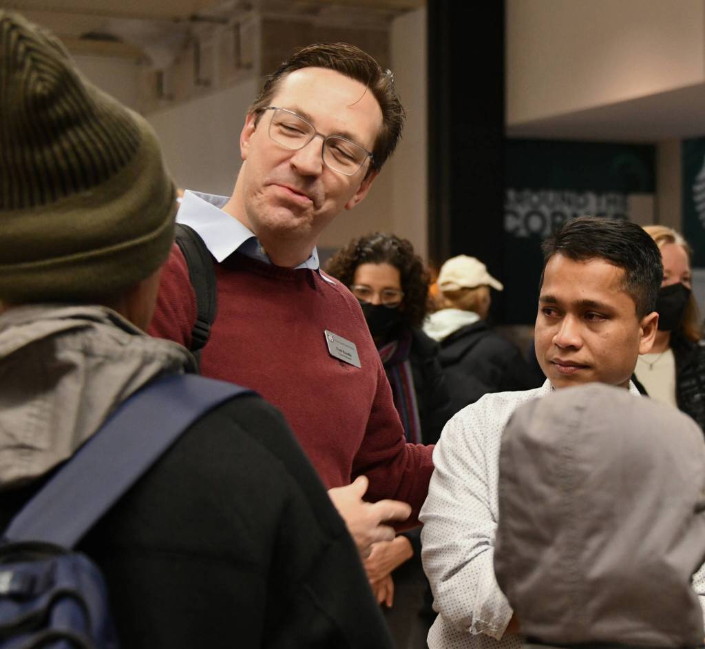 Mercer Island School District Superintendent Fred Rundle joins Mohamad Imran while speaking to his father. Andy Nystrom/ staff photo