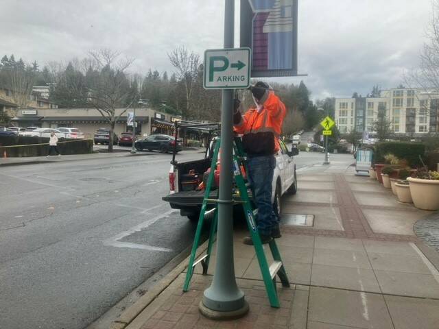 A city worker places parking signage in Town Center. Photo courtesy of the city of Mercer Island