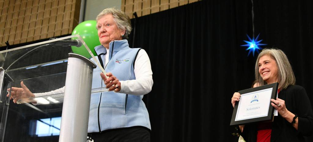 Solemates founder Fran Call speaks to the crowd after accepting the Philanthropy Award for the walking and social group at the 22nd annual Mercer Island Youth and Family Services Foundation fundraising breakfast on Feb. 7 at the Mercer Island Community and Event Center. Friendship Circle Executive Officer Sari Weiss, right, presented the award to the group of men and women  ages 55 and up  who are dedicated volunteers and fundraisers in the community. Andy Nystrom/ staff photo
