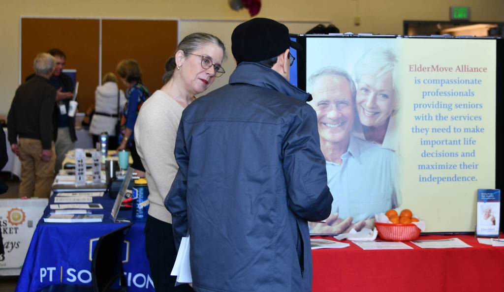 An attendee gains information at the ElderMove Alliance booth. Andy Nystrom/ staff photo
