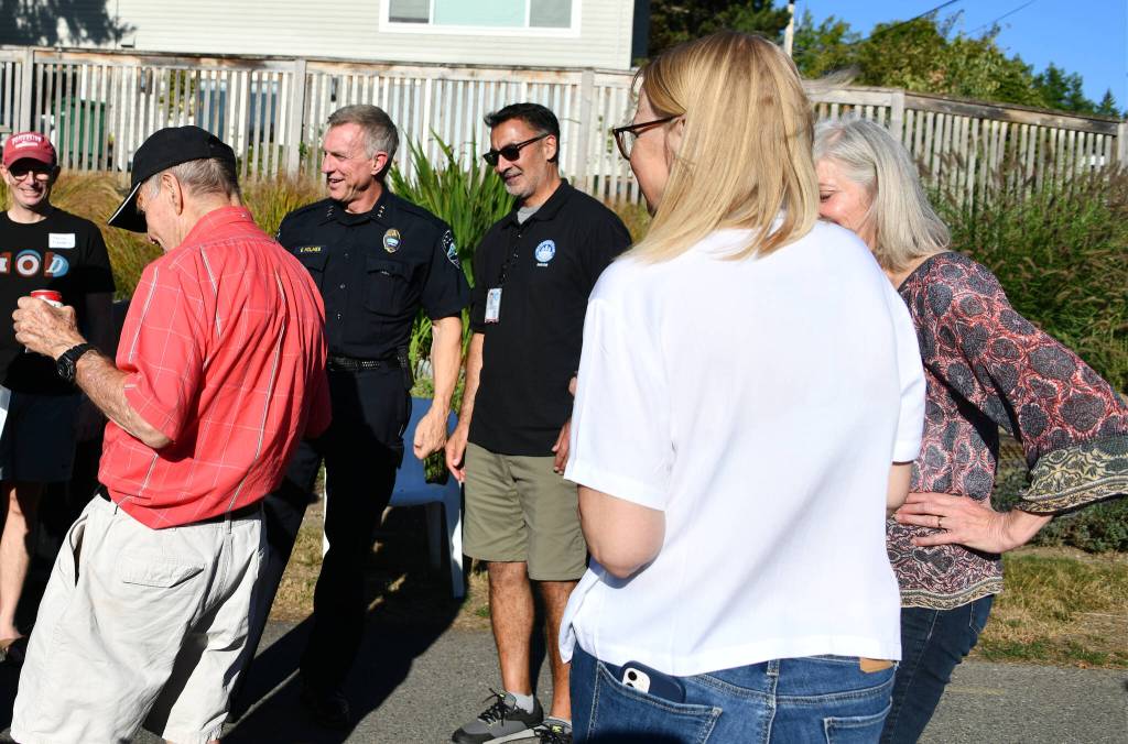 Mercer Island Police Department Chief Ed Holmes, center, visits with residents at a National Night Out event at Rep. Tana Senns home on Aug. 1, 2023. To Holmes right is Mayor Salim Nice. Andy Nystrom/ staff photo