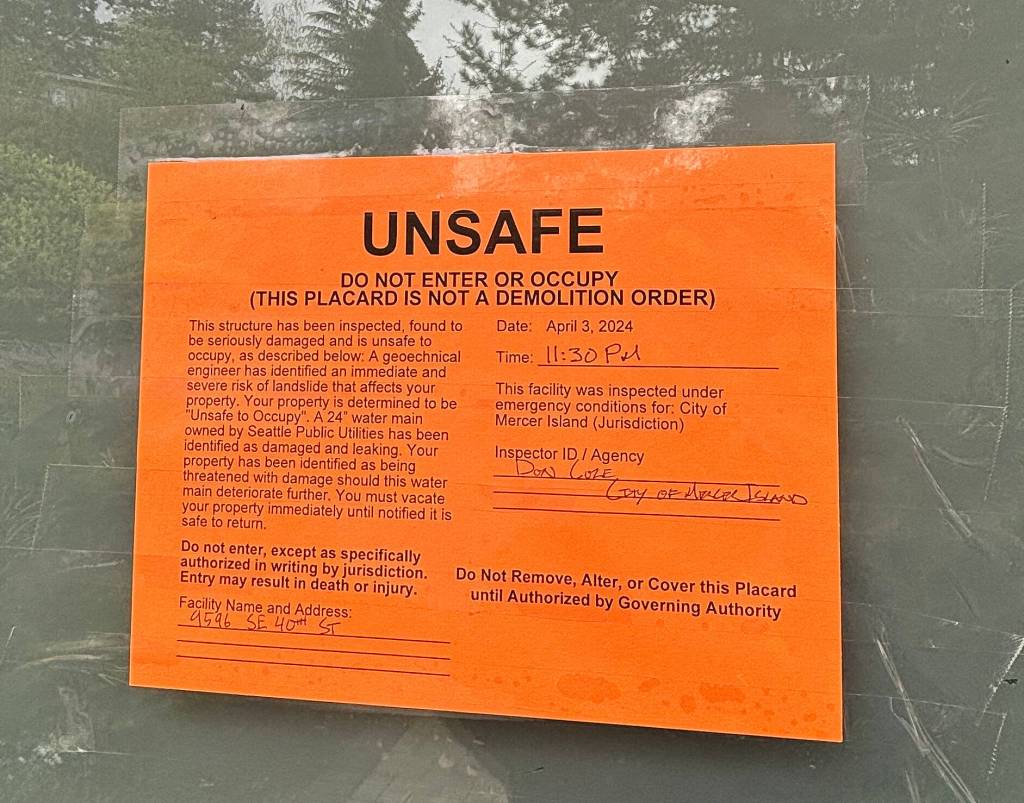 Some residents near 95th Court Southeast have these signs taped to their doors describing the landslide risk and were directed to evacuate their premises on April 3. Andy Nystrom/staff photo