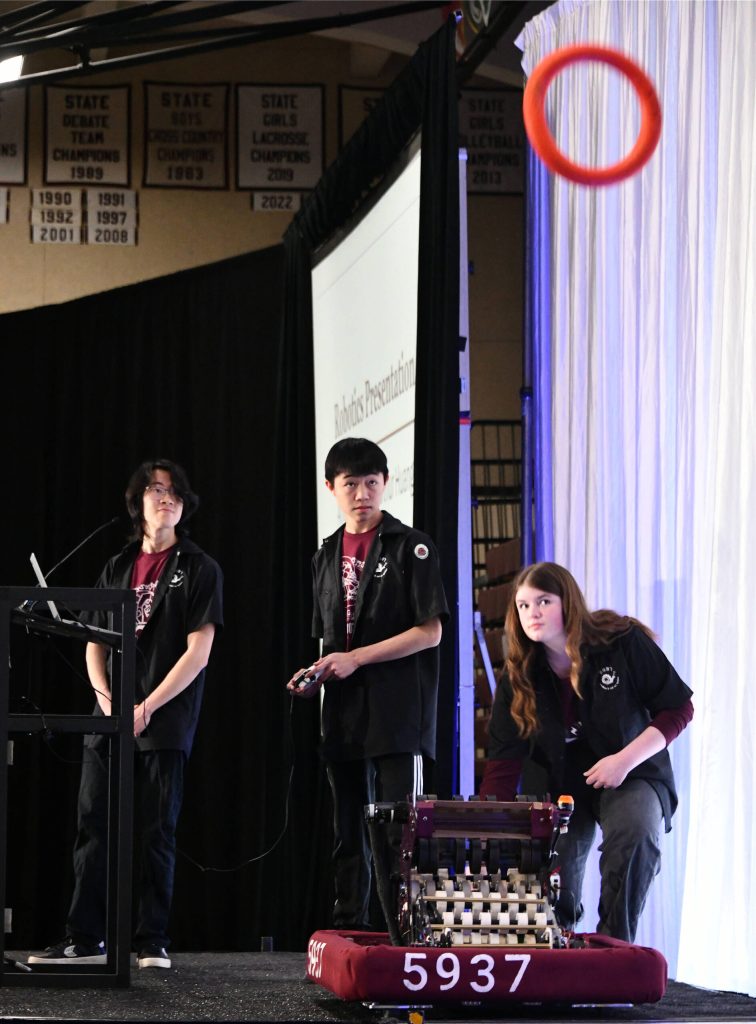 Mercer Island High School robotics students Amelia Bernson, Arthur Huang and Joshua Yeh launch an orange ring during their presentation. Andy Nystrom/ staff photo
