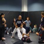 Hanaumi and a volunteer show participants how to defend on the ground before they break out to practice in pairs. (Cameron Sires/ Sound Publishing)