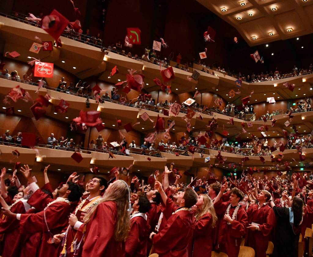 Graduates toss their diplomas into the air. Andy Nystrom/ staff photo