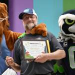 Seahawks mascot Blitz and Leo the Lion (Mercer Island School District Superintendent Dr. Fred Rundle) flank Lakeridge Elementary School head custodian Bob Hanson during a school assembly on June 11. The school celebrated Hanson, who is retiring after 35 years at Lakeridge and 38 overall with the district. Andy Nystrom/ staff photo