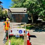 A city worker flanks a variable message sign on Mercer Island regarding immediate water conservation. Photo courtesy of the city of Mercer Island