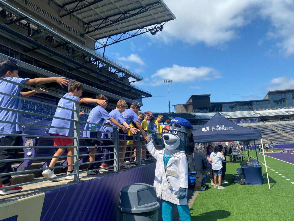 Health E. Hound high fives kids at Summer Field Day. Photo courtesy of UnitedHealthcare Community Plan of Washington