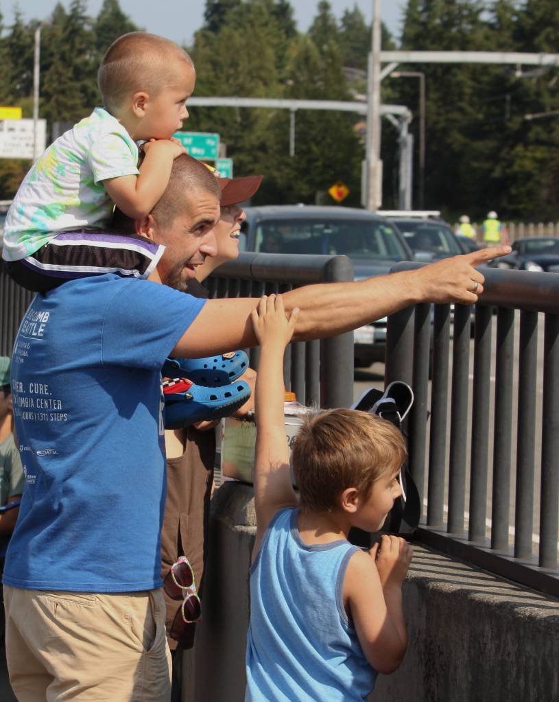 Andy Nystrom/ staff photo
Marcin Lobrow of Mill Creek points toward the Blue Angels while his sons, Oliver, 3 (top), and Tomek, 7, and wife, Michelle, watch the action on Aug. 2 from the Interstate 90 pedestrian/biking walkway near Mercer Island. Also present was their son Franek, 8.