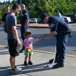 Eastside Fire & Rescues Josh Stalker gives Viki Younger, 3, a National Night Out sticker while her dad Robert watches on Aug. 6 at the Mercer Island Community and Event Center. Andy Nystrom/ staff photo