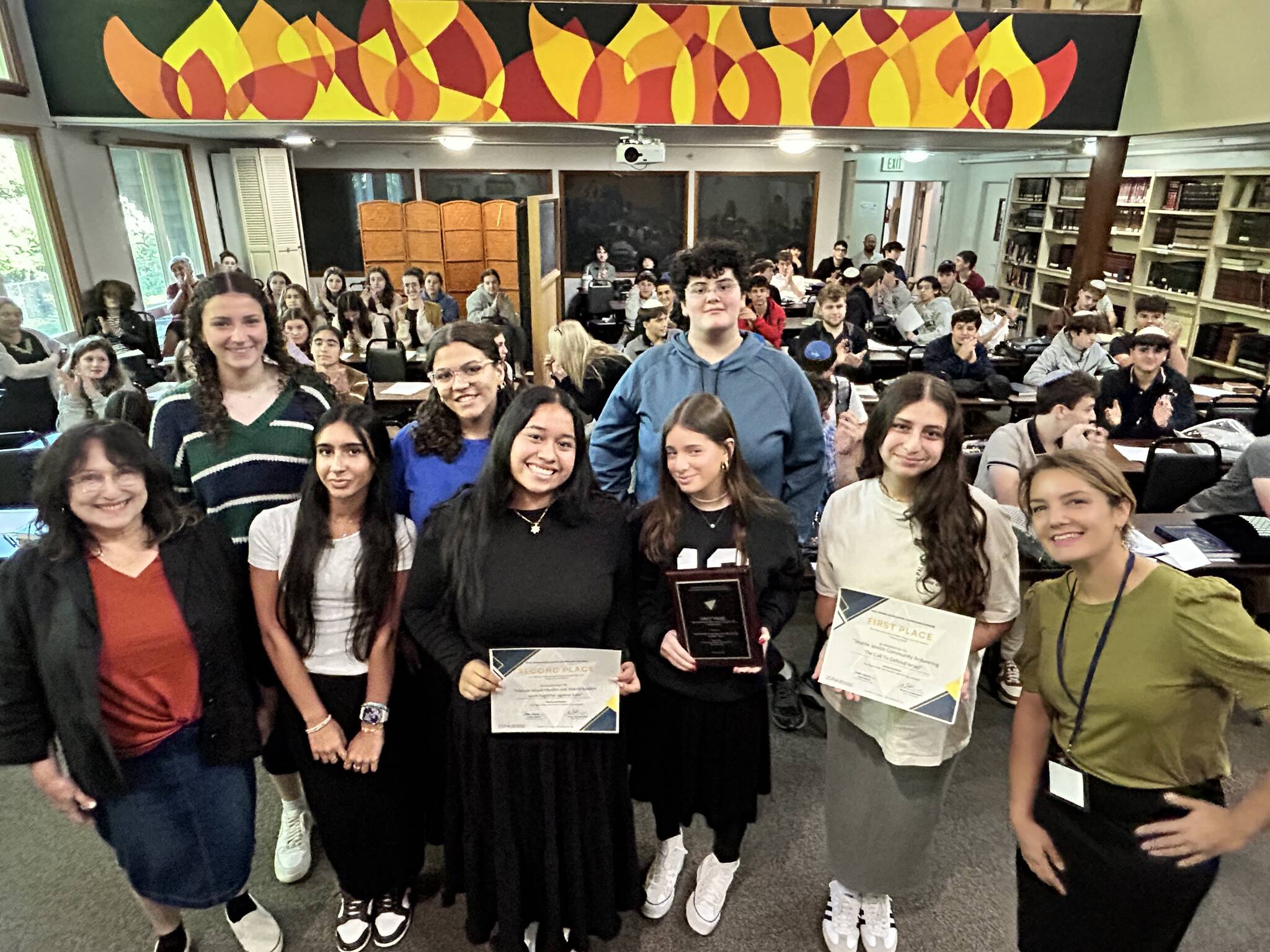 Joelle Keene, president and executive director of the Jewish Scholastic Press Association, visited Northwest Yeshiva High School (NYHS) on Aug. 29 to present a pair of awards to local students in the Emily Alhadeff-taught journalism department. Students received awards for their feature stories in the high school newspaper, The Mane Idea. Jenna Kaufthal, a recent NYHS graduate, won first place in a tie with Shalhevet High School in the category of News and feature reporting on current events involving Israel. The article, titled Answering the Call to Defend Israel, was featured by The Mane Idea in December of 2023. Elianna Rothstein, now an NYHS senior, won second place in the category of News or feature reporting on interreligious or intercultural activism or events for her December 2023 piece titled, Mercer Island Muslim and Jewish leaders work together against hate. Photo courtesy of Zelle Rettman