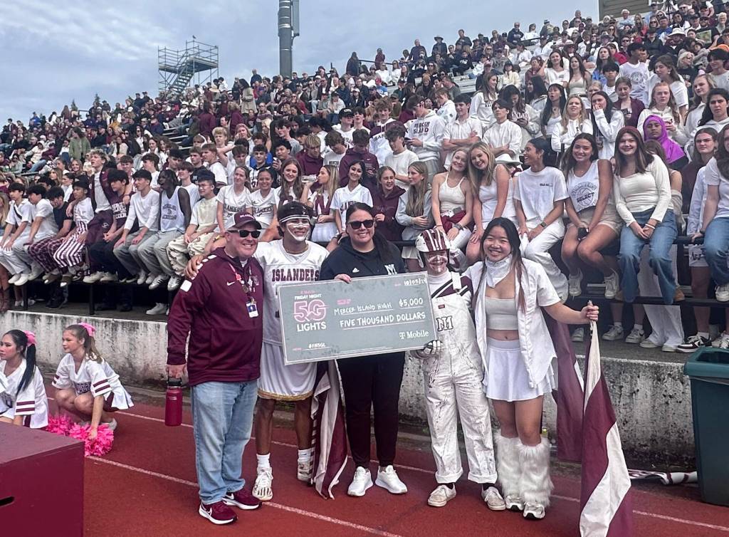 Mercer Island High School Principal Nick Wold and Athletic Director Lindsey Blaine celebrate with students during the Oct. 5 Homecoming football game at Islander Stadium on being named a T-Mobile Friday Night 5G Lights program $5K winner. The Islanders beat Newport, 31-10. Islander fans lent overwhelming support and school spirit to get the T-Mobile win. Local T-Mobile representative Jay Lee and staff members presented a $5,000 check to Blaine at halftime. The schools next goal is to be named a top 16 finalist. Island resident Rob Wolf apprised the school about the promotion. Photo courtesy of the Mercer Island School District