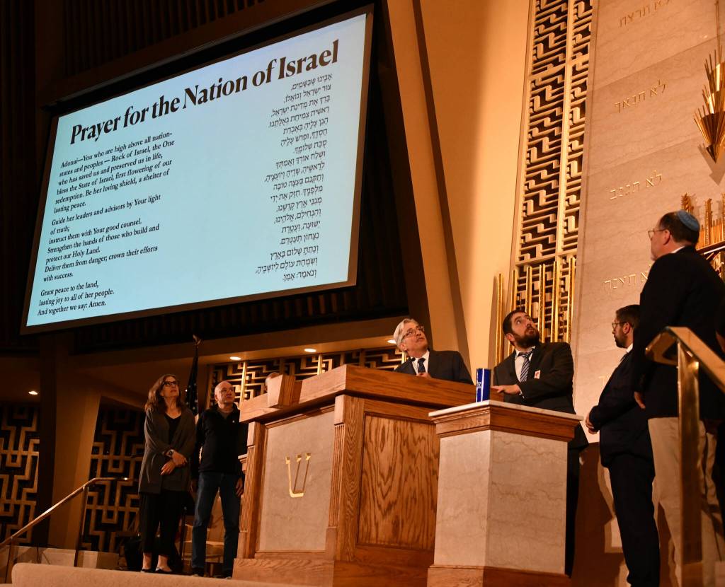 Attendees take the stage to recite the Prayer for the Nation of Israel at the October 7: One Year Later commemoration. Andy Nystrom/ staff photo