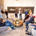 Amer Zahr (left), a Palestinian Arab American comedian, speaker, writer, academic and adjunct professor at University of Detroit Mercy School of Law, meets with attendees at the SZ Gallery on Oct. 11 on Mercer Island. Also pictured is a portion of the Control Anatomy exhibit by Palestinian artist Mahmoud Alhaj. Photo courtesy of Flora Art Life