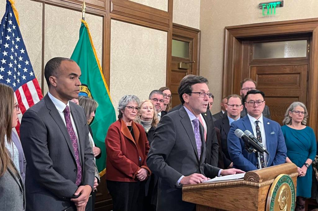 Gov. Bob Ferguson, surrounded by other state elected leaders, speaks at a Feb. 13 press conference in Olympia. (Photo by Bill Lucia/Washington State Standard)