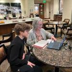 Sean Barneson helps Deanna Meine, 86, set up her laptop. Photo courtesy of Colleen Barneson