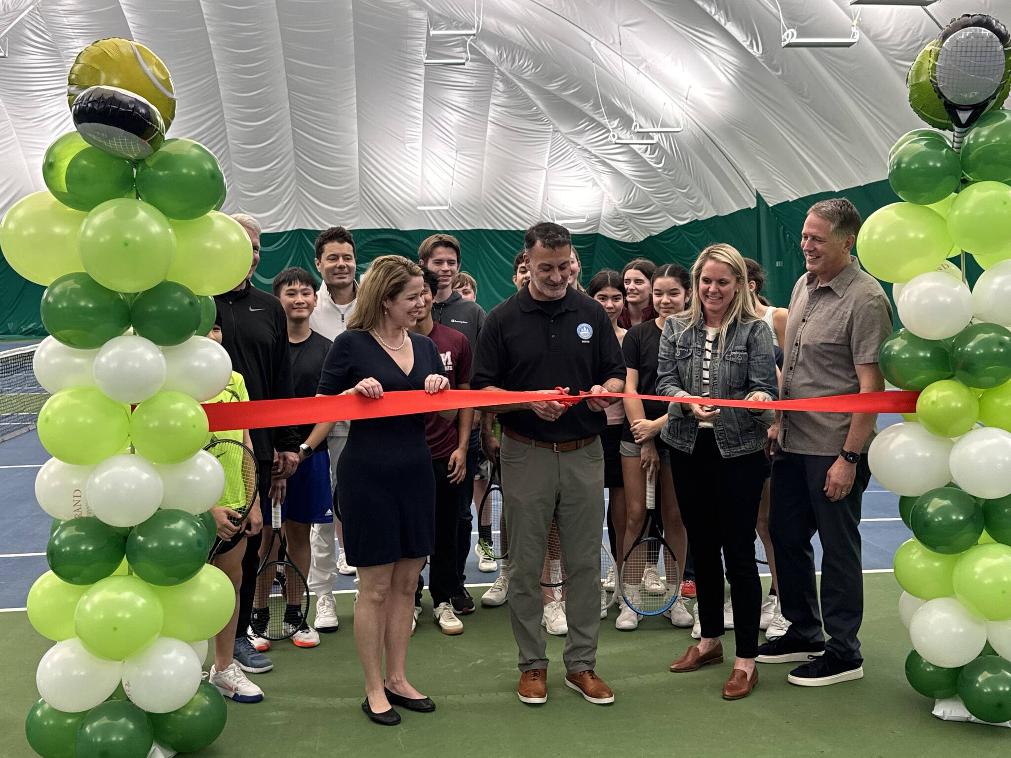 Front row: Mercer Island Country Club (MICC) board President Susie Vannatter, Mercer Island Mayor Salim Nice, MICC General Manager Dorrinda Pierce and MICC former board president Dan Nordale. Back row: MICC Tennis Director Doug McLaughlin, tennis coach Jesse Walter and the MICC Juniors Tennis Team. The group gathered at the MICC ribbon-cutting ceremony on Feb. 28 for its new tennis/pickleball bubble. Courtesy photo