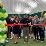 Front row: Mercer Island Country Club (MICC) board President Susie Vannatter, Mercer Island Mayor Salim Nice, MICC General Manager Dorrinda Pierce and MICC former board president Dan Nordale. Back row: MICC Tennis Director Doug McLaughlin, tennis coach Jesse Walter and the MICC Juniors Tennis Team. The group gathered at the MICC ribbon-cutting ceremony on Feb. 28 for its new tennis/pickleball bubble. Courtesy photo