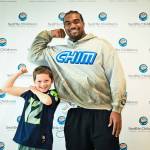 Emerson Vivion flexes his muscle with former Seattle Seahawk Tyrel Dodson. (Photo courtesy of the Seattle Seahawks)