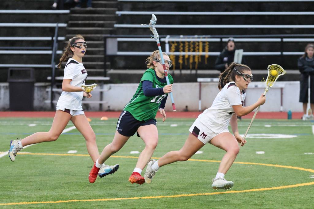 Mercer Island High School senior Sophia Loiselle, right, moves the ball up field against Woodinville High School. In back is Islander sophomore Lulu Carr. Photo courtesy of Rick Edelman