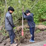 Vireen Pareek, left, and Bowen Nago hold the post hole digger. Courtesy photo