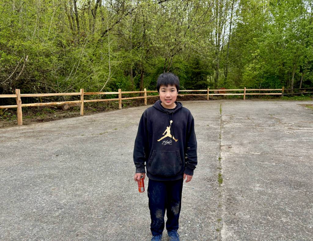 Bowen Nago in front of the newly built fence. Courtesy photo