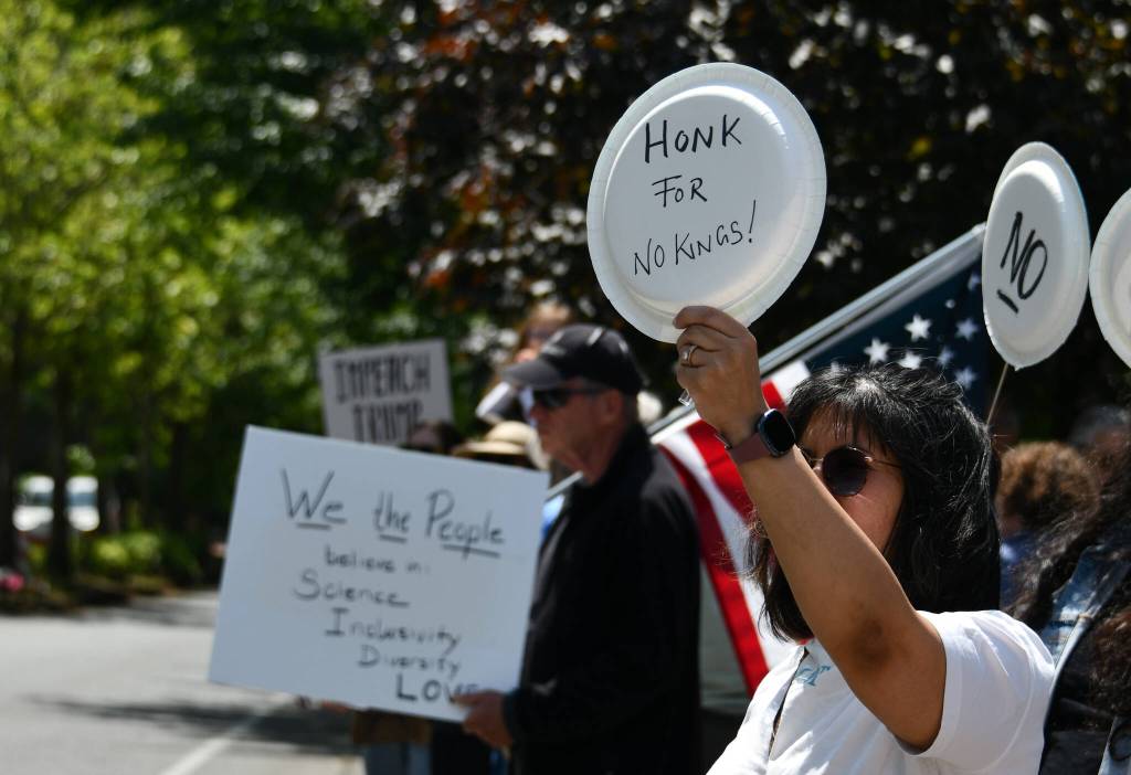 Pashmi Vaney displays her sign for drivers to see at the June 14 No Kings rally on Mercer Island. Andy Nystrom / staff photo