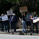Mercer Island No Kings rally attendees display their signs along 78th Avenue Southeast in front of Mercerdale Park. Andy Nystrom/ staff photo