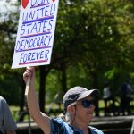 A resident shows appreciation for a drivers honk at the No Kings rally on Mercer Island. Andy Nystrom/ staff photo