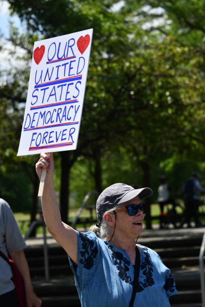 A resident shows appreciation for a drivers honk at the No Kings rally on Mercer Island. Andy Nystrom/ staff photo