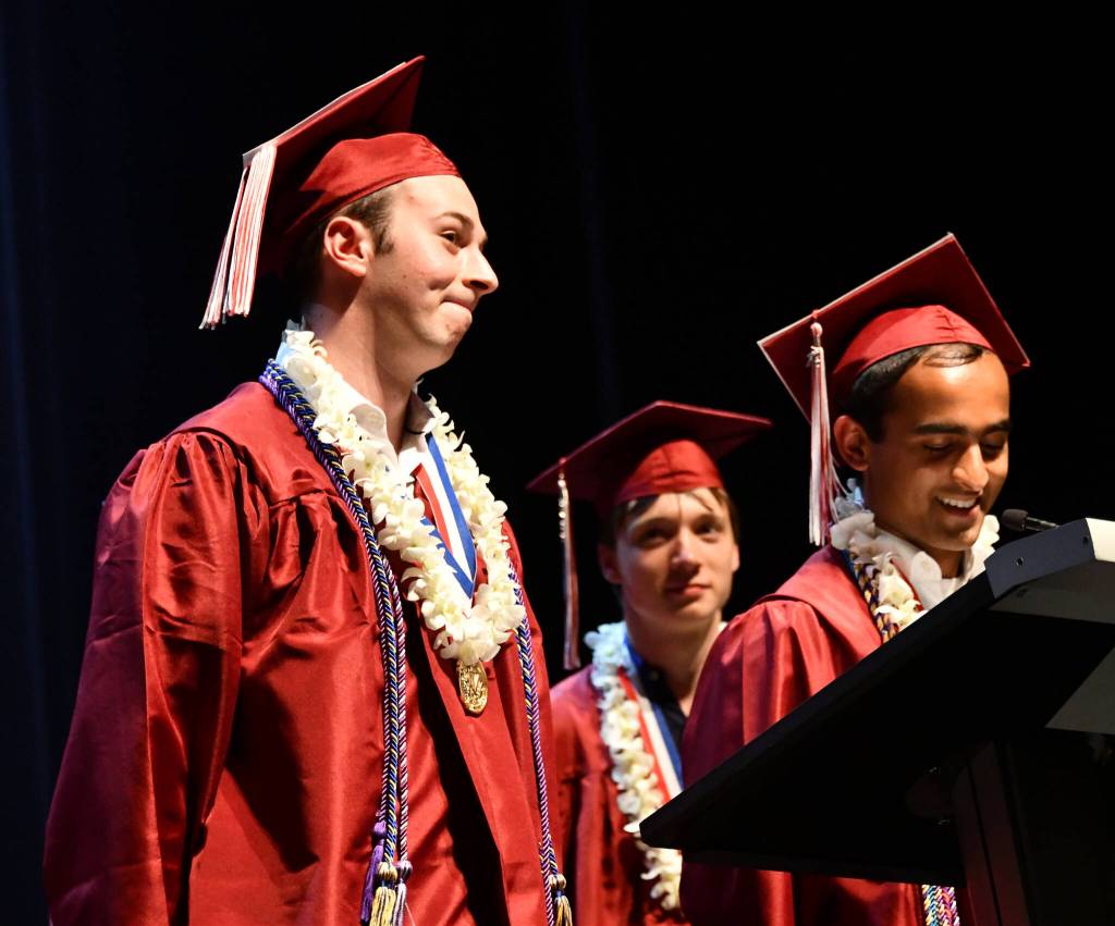 Kyle Gerstel, left, and Ashwin Krishnaswamy, right, with Nikita Kovarskas during the 14-student valedictorian speech. Andy Nystrom/ staff photo