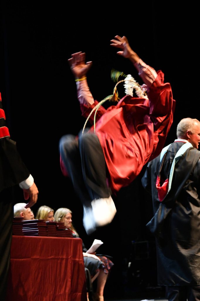 A graduate performs a backflip on stage after receiving his diploma. Andy Nystrom/ staff photos