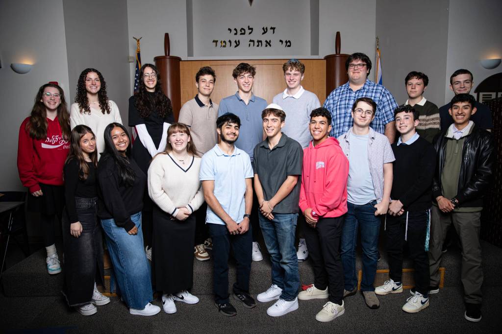 Northwest Yeshiva High Schools Class of 2025 graduation ceremony took place on June 5 at Sephardic Bikur Holim Congregation in Seward Park. Eighteen of the 19 graduates are pictured. They are: Front row left to right: Elianna Rothstein, Leah Gonzalez, Ariana Balkany, Eli Khaimov, Rubin Owen, Sol Levy, Didi Desmond, Izzy Hoffman and Emmanuel Spinoza; back row left to right: Celia Rosenbaum, Paulina Gamel, Evelyn Edwards, Isaac Almo, Ben Weichbrodt, Joe Benoliel, Noam Rosenfeld, Zach Saltsman and Jacob Klinghoffer. Not pictured: Amiel Robicsek. Photo courtesy of Mason Kelley