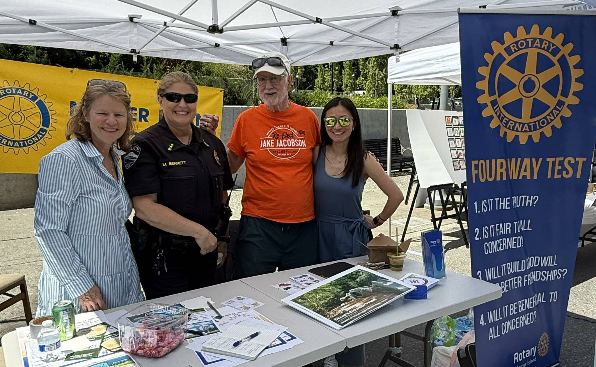 Rotarian Diane Tien, MI Police Chief Michelle Bennett, and Rotarians John Hamer and Linnea Augustine at Rotarys Summer Celebration table. Courtesy photo.