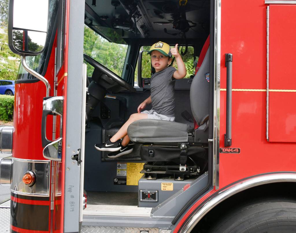 Mercer Island resident Drew Young sits in the drivers seat of an Eastside Fire & Rescue truck on Aug. 5 at the citys National Night Out event at the city hall parking lot. Drews dad, Ryan, said his son loves anything and everything about trucks. Ryan added that they support community events and those people who keep the community safe. Andy Nystrom/ staff photo