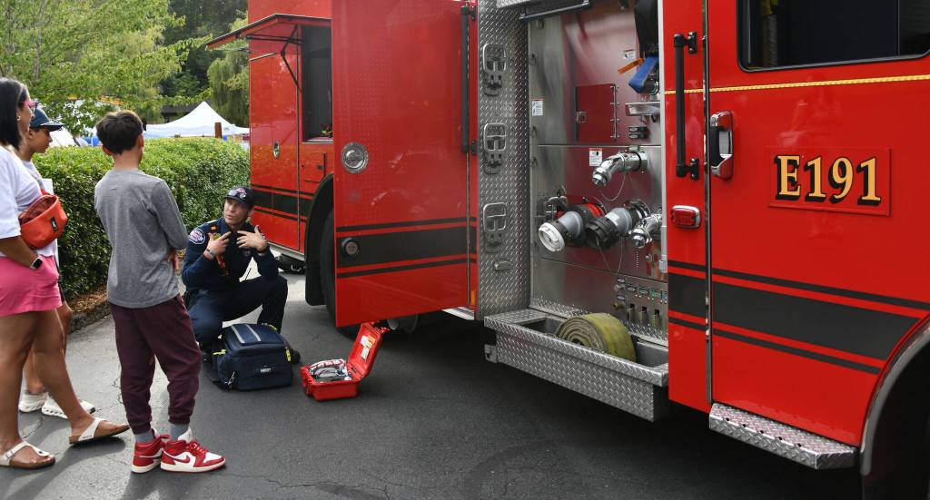 Eastside Fire & Rescues Jace Hinesly discusses his job with Mercer Island residents Nidhi Chappell and her sons, Davin and Aaron. Andy Nystrom/staff photo