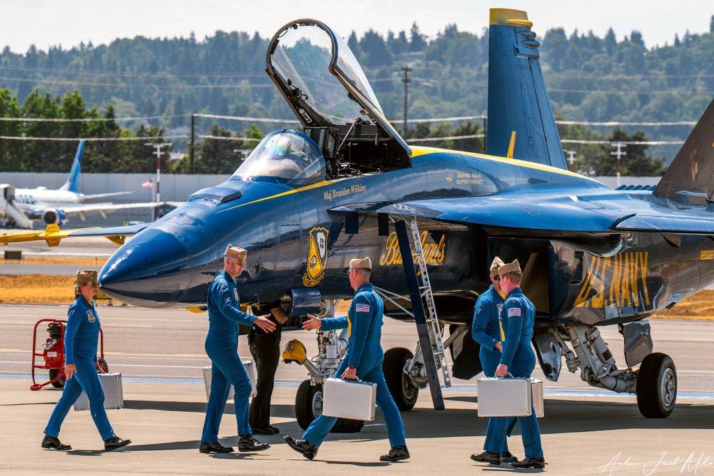 Blue Angels pilots return to the tarmac at Boeing Field after their flight, carrying flight gear bags holding helmets, oxygen masks, and other essentials. Photo courtesy of Andrew Meade