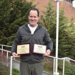 Former Mercer Island High School teacher Chris Twombley poses with a pair of awards for the schools student newspaper in March 2019. This photo was posted on the school districts Facebook page. Courtesy photo