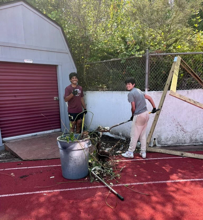 Mercer Island High School football players Eshaan Pastel and CJ Greenfield participate in a school field cleanup day on Aug. 1. Courtesy photo