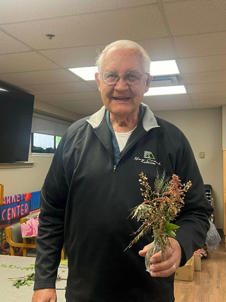 Mercer Island Covenant Living at the Shores resident Einer Handeland holds some of the filler plants he used for the 80-plus bouquets that he made for the Shores boards guests. Courtesy photo