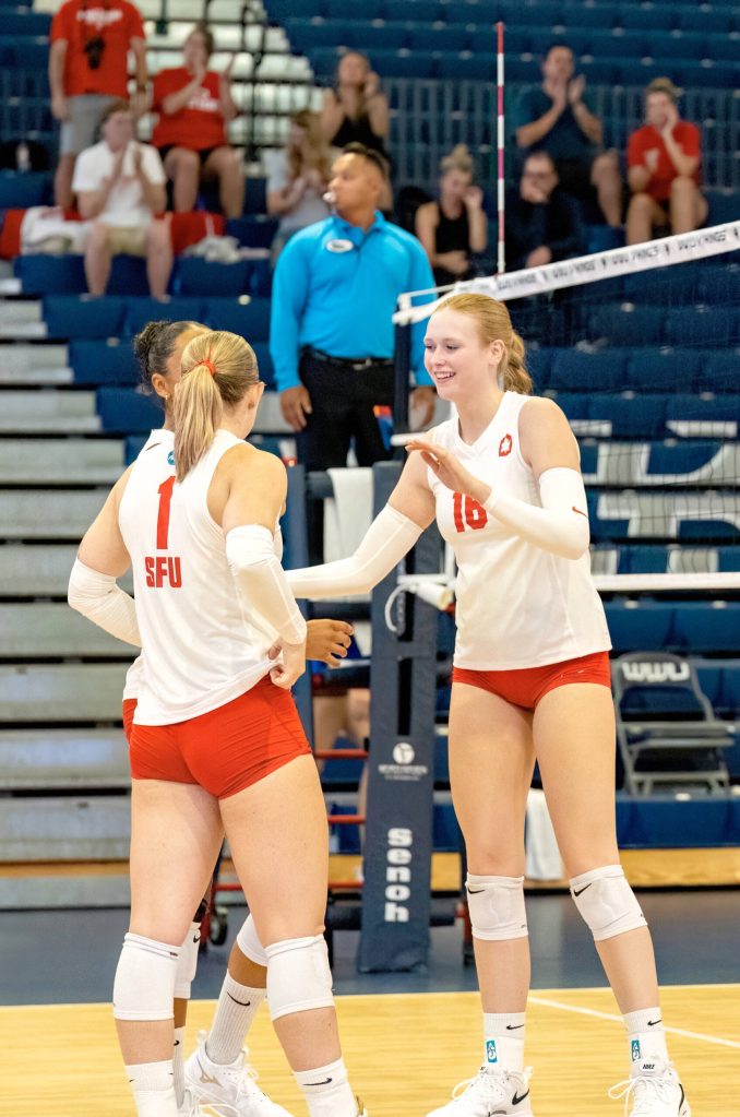 Mercer Islands Logan Remington, right, celebrates with her Simon Fraser University volleyball teammates during her record-setting game versus San Francisco State on Sept. 5 at Western Washington University. Photo courtesy of Jeff Evans / Western Washington University