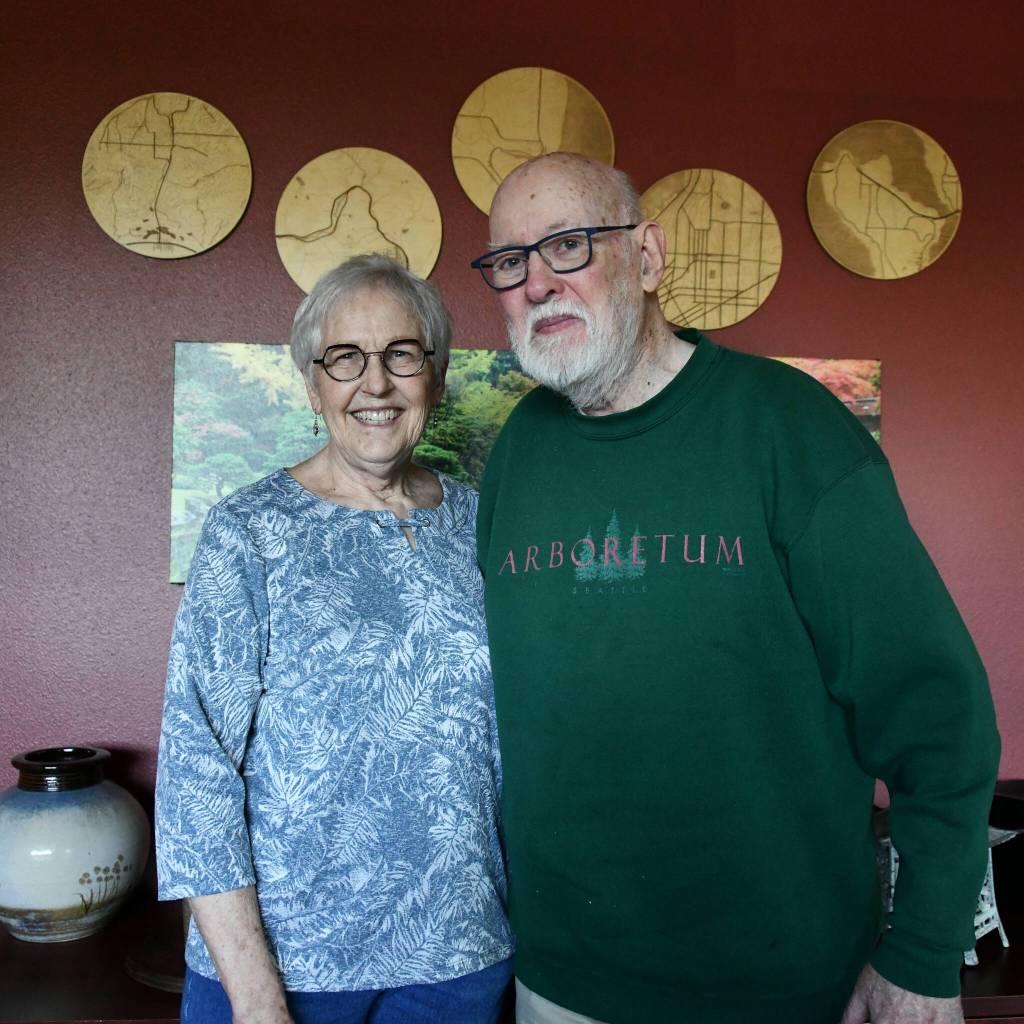 Peggy and Steve Garber stand in their Aljoya Mercer Island unit, which features maps of places they used to live: Reardon (Lincoln County), Snoqualmie Pass, Brownsville (Kitsap), Seattle, and Mercer Island/Bellevue. Their daughter-in-law made the items for Steves 80th birthday. Andy Nystrom/ staff photo