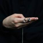 A former student at Mercer Island High School poses for an anonymous portrait while holding two Tiffany necklaces outside her apartment on Oct 13, 2025. The former student, who graduated in 2011, says that former English teacher Curtis Johnston pursued an inappropriate sexual relationship with her during her senior year of high school, which extended through her freshman year of college. When she left for college, Johnston gifted her the necklaces. (Moe K. Clark/InvestigateWest)