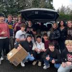 Mercer Island High School AP microeconomics students in a group photo in front of a car loaded with donated food items for the Fall City Food Pantry. Photo courtesy of the Mercer Island School District