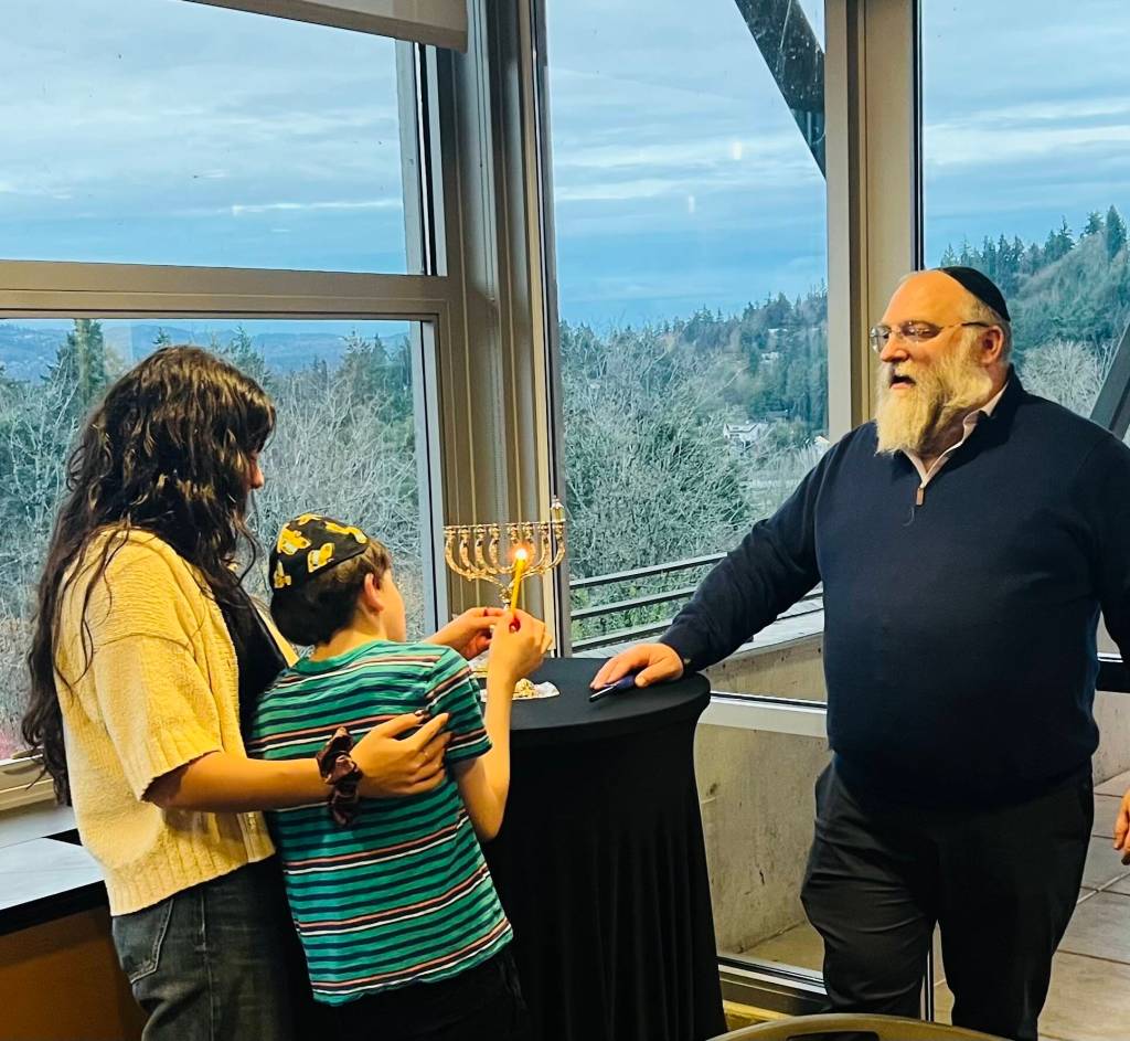 The Friendship Circle of Washington, which is based on Mercer Island, held a menorah lighting, Chanukah celebration and festivity on Dec. 14 at the Mercer Island Community and Event Center. Pictured is Mathew, 16, lighting the menorah as a volunteer and Rabbi Elazar Bogomilsky watch. Also pictured below is a performer in the outdoor entertainment light show. In a letter to the editor to the Mercer Island Reporter , Rabbi Bogomilsky said, in part: As we light the first candle, lets hold in our hearts the holy souls who perished in Bondi Beach, and send prayers for healing and a speedy recovery to all who are injured and hurting. Photos courtesy of Marina Prossin