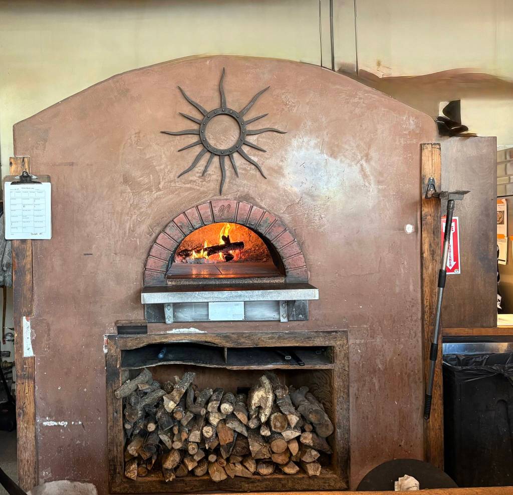 Wood-fired pizza oven at Solstice Pizza.